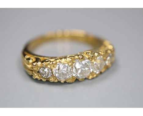 A modern Victorian style 18ct gold and graduated old round cut diamond set half hoop ring, with carved shank, size L, gross 5