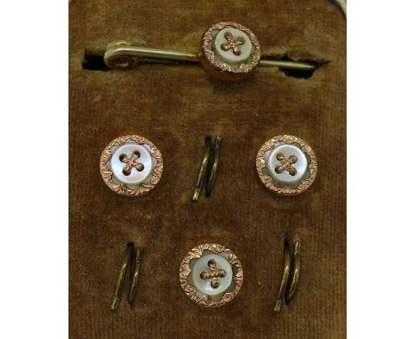 A mother of pearl and gilt metal button and tie pin set