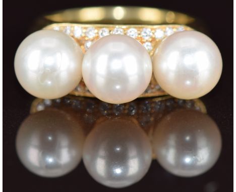An 18ct gold ring set with three cultured pearls, each approximately 8mm, surrounded by diamonds, 13g, size O
