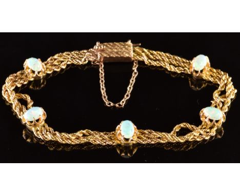 A c1910 9ct gold three strand rope twist bracelet set with five oval opal cabochons, 9.4g, 17cm