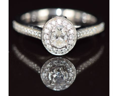 Jenny Packham 18ct&nbsp;white&nbsp;gold ring set with an oval cut diamond surrounded by further diamonds, and with diamonds t