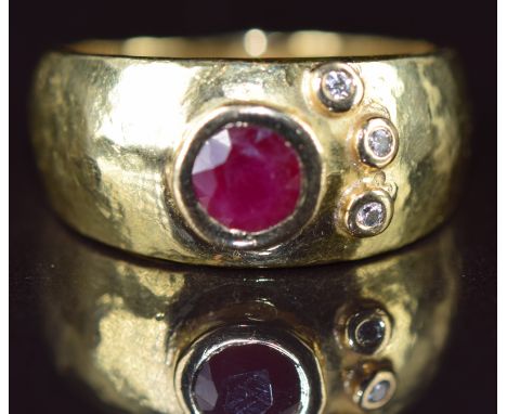 An 18ct gold ring set with a round cut ruby of approximately 0.35ct and three diamonds, 6g, size L