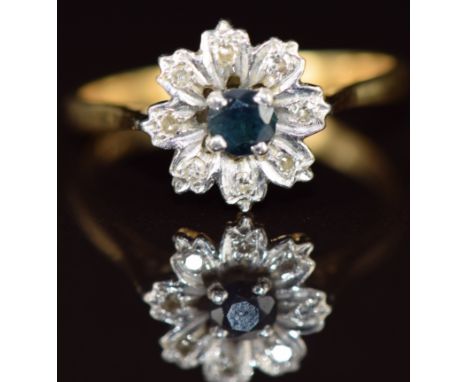An 18ct gold ring set with a round cut sapphire surrounded by diamonds in a floral cluster, 3.1g,&nbsp;size P