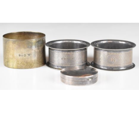 Three various hallmarked silver napkin rings including a pair of engine turned examples, together with a hallmarked silver pi