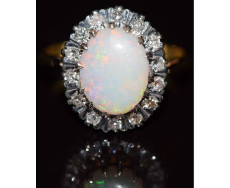 An 18ct gold ring set with an oval cut opal surrounded by diamonds, 4g, size L