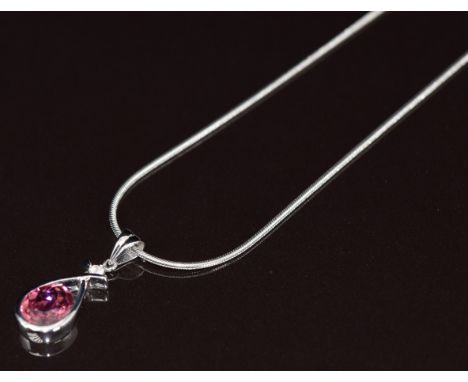 An 18ct white gold pendant set with an oval cut tourmaline of approximately 1.6ct and a round cut diamond of approximately 0.