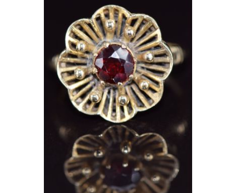 A 9ct gold ring set with a garnet in a floral setting, 4.4g, size M
