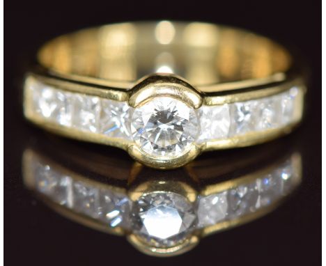 An 18ct gold ring set with a round cut diamond and eight princess cut diamonds, the largest diamond approximately 0.35ct, the