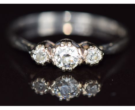 A platinum ring set with three diamonds, the centre diamond approximately 0.26ct, 2.7g, size S