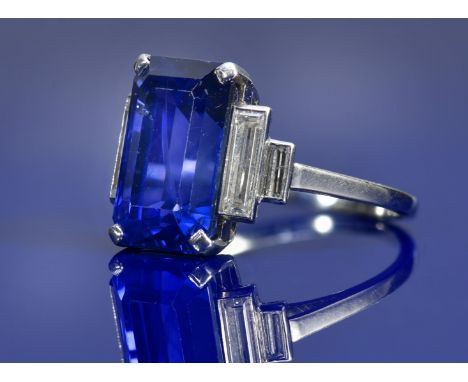 A platinum ring set with an emerald cut sapphire measuring 8.55ct and two baguette cut diamonds to each shoulder, the total d