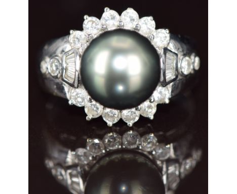 An 18k white gold ring set with a Tahitian pearl measuring approximately 10.5mm surrounded by round and baguette cut diamonds