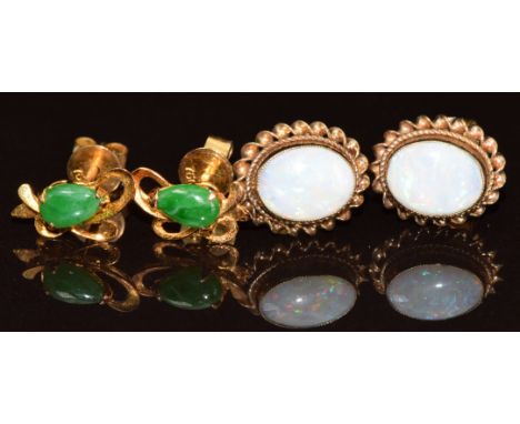 A pair of 18ct gold earrings each set with a pear cut jadeite cabochon (1.2g) and a pair of 9ct gold earrings each set with a