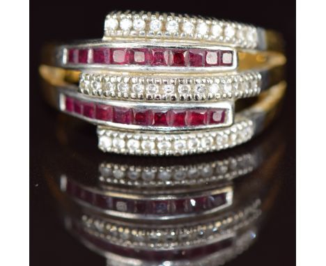 An 18ct gold ring set with calibre cut rubies and round cut diamonds, the total ruby weight approximately 1.3ct and diamonds 