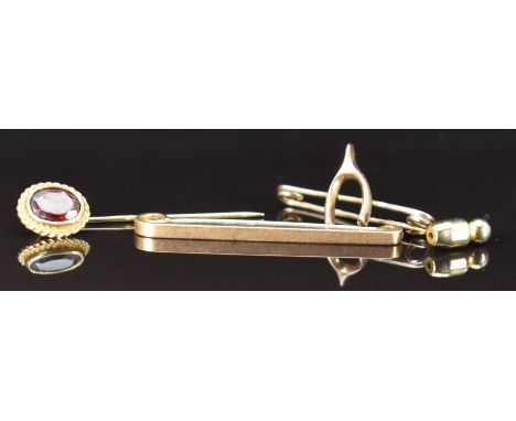 A 9ct gold brooch in the form of a wishbone, 9ct gold stick pin set with a garnet and a 9ct gold brooch, 3g