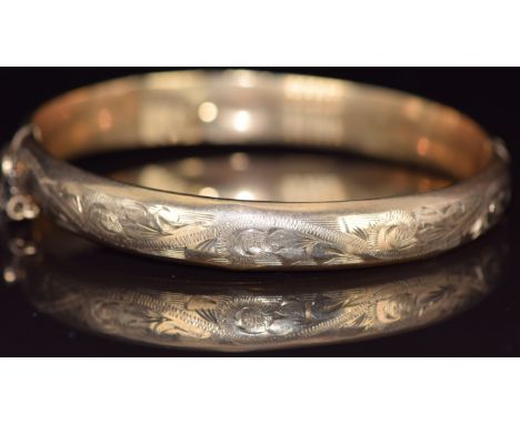 A 9ct gold bangle with engraved decoration, 10g, 5.6 x 5.8cm 