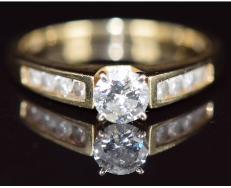 A 14k gold ring set with a round cut diamond of approximately 0.46ct and with further diamonds to the shoulders, 3g, size O