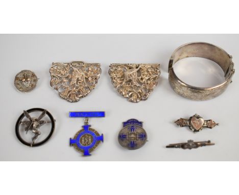 A hallmarked silver nurse's buckle, two silver nursing brooches, Victorian silver brooch with applied gold detail (Birmingham