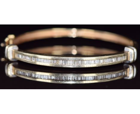 A 14ct gold bangle set with baguette cut diamonds, 16.2g, 5.8 x 5.2cm&nbsp;