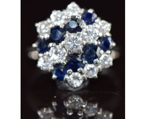 An 18ct white gold ring set with round cut diamonds and sapphires in a cluster, the largest diamond 0.16ct, 4.3g, size L