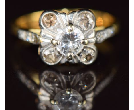 An 18ct gold ring set with a diamond of approximately 0.4ct and four smaller diamonds, in a platinum mount with diamond set s