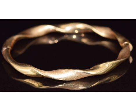 An 18ct gold bangle in a twist design with brushed finish, 8.9g, 5.9 x 5.2cm