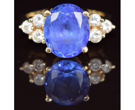 An 18ct gold ring set with an oval cut tanzanite of approximately 5ct and three round cut diamonds of approximately 0.08ct to