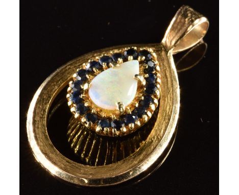 A 9ct and 18ct gold pendant set with a pear cut opal surrounded by sapphires, 7.3g, 3.5 x 2.2cm