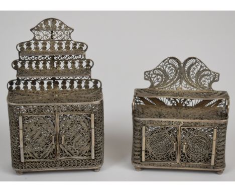 Pair of filigree silver novelty miniature or doll's house sideboards, with shelf above, opening doors and raised on bun feet,