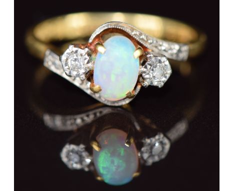 An 18ct gold ring set with an opal cabochon and diamonds in a platinum setting, 4g, size M