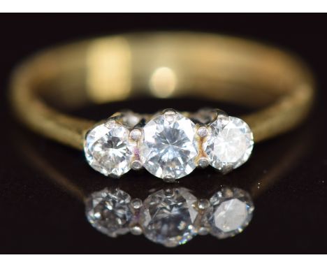 An 18ct gold ring set with three diamonds, the centre diamond approximately 0.2ct, 2g, size K