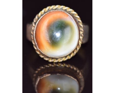 A 9ct gold ring set with a operculum shell, 7g, size P