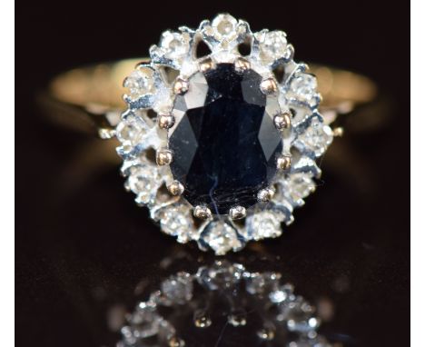 A 9ct gold ring set with an oval cut sapphire surrounded by diamonds, 2.7g, size M