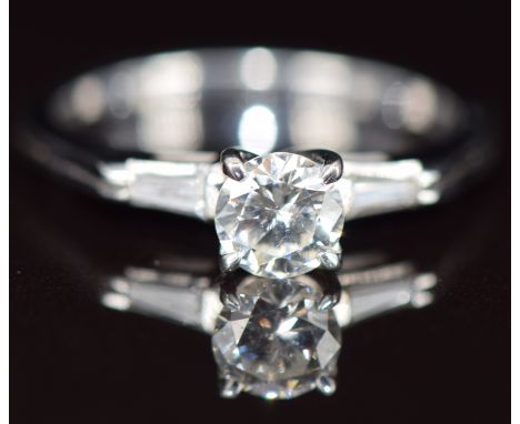An 18k white gold ring set with a round cut diamond of approximately 0.5ct with a further baguette cut diamond to each should