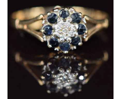 A 9ct gold ring set with a diamond surrounded by sapphires, 1.7g, size O