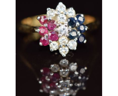 An 18ct gold ring set with diamonds, sapphires and rubies in a cluster, 3.6g, size M