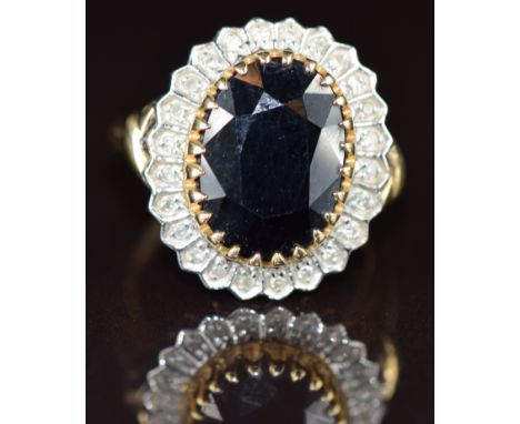 A 9ct gold ring set with an oval cut sapphire surrounded by diamonds totalling approximately 0.12ct, 5.5g, size N