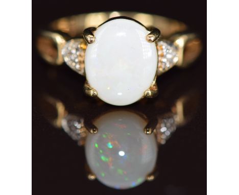 A 9k gold ring set with an opal cabochon and white sapphires, 4.3g, size N