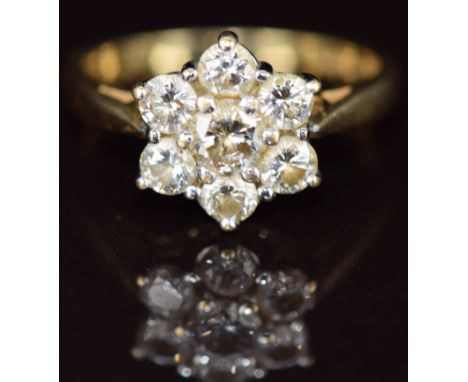 An 18ct gold ring set with seven round cut diamonds in a cluster, the centre diamond approximately 0.4ct, total diamond weigh