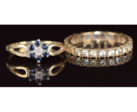 A 9ct gold eternity ring and a 9ct gold ring set with a diamond surrounded by sapphires, 4.2g, size R &amp; O