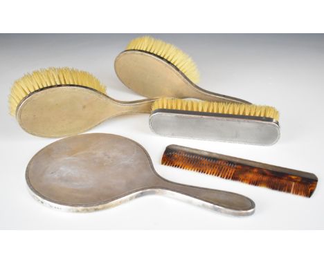 Art Deco style hallmarked silver dressing table set comprising hand mirror, three brushes and a comb, London 1961, maker D C 