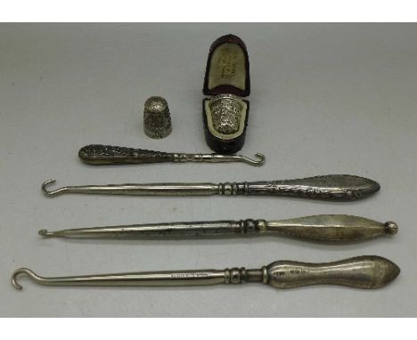 A silver Charles Horner thimble, cased, a/f, one other thimble and four silver handled button hooks