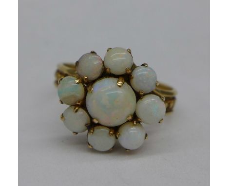 A 9ct gold, opal cluster ring, centre stone 7mm in diameter, 4g, O