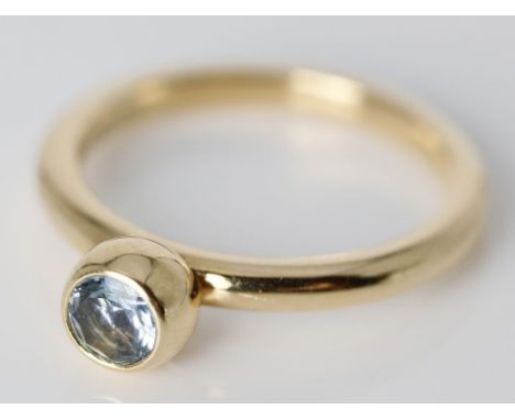 Ring, Gübelin. 750/000 GG, brutto 3,6 g. Ringkopf besetzt mit blauem Zirkon, Innenschiene wohl besetzt mit kl. Rubin. Ggem. G