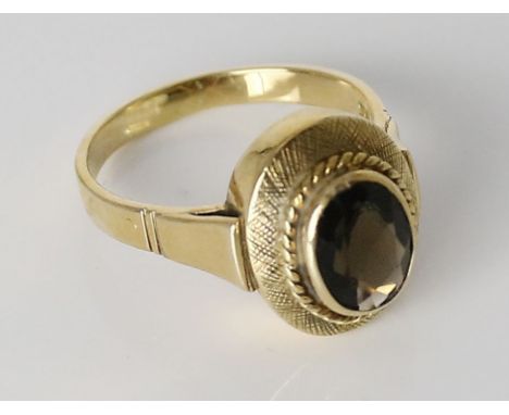 Ring. 585/000 GG, brutto 7,3 g. Ringkopf besetzt mit oval facettiertem Rauchquarz. RW 62/63. 