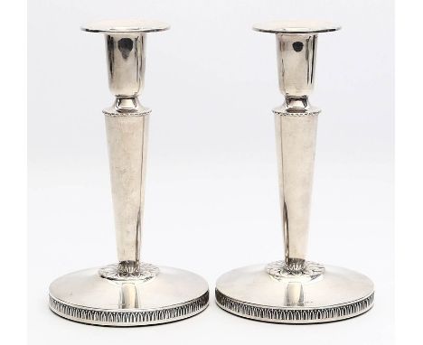 Paar elegante Leuchter, je einflammig. 830/000 Silber (gefüllt). Konischer Schaft auf Scheibenfuß mit Akanthusrelief. Kratzer