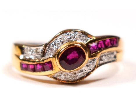 An 18ct gold (750) ruby and diamond ring, collet set with an oval mixed cut stone , flanked by baguettes, brilliant cut diamo