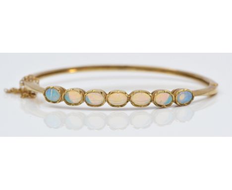 A vintage 9ct gold seven stone opal bracelet, London 1993, collet set with cabochon stones, 56 x 50mm internal, 11.1gm