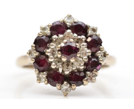 An 18ct white gold ruby and brilliant cut diamond cluster ring, L, 5.6gm