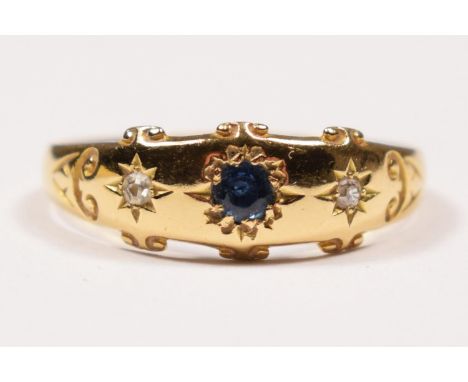 An Edwardian 18ct gold sapphire and diamond star gypsy set three stone ring, Birmingham 1905, T, 2.8gm.