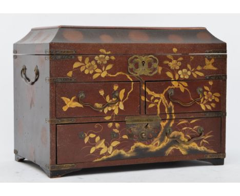 A Japanese lacquer jewellery box, with red and gold floral decoration, hinged lid revealing a fitted interior, over two short